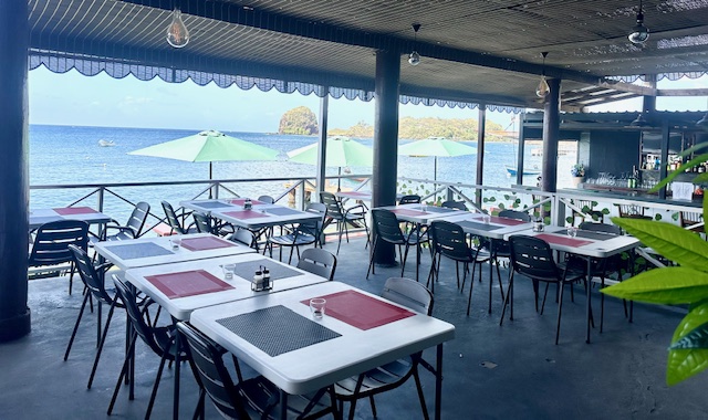 A restaurant with tables and chairs outside of the building